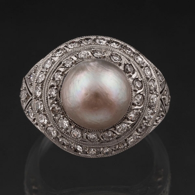 Sortija en oro blanco de 18kt con perla central cultivada y doble orla de diamantes talla brillante.