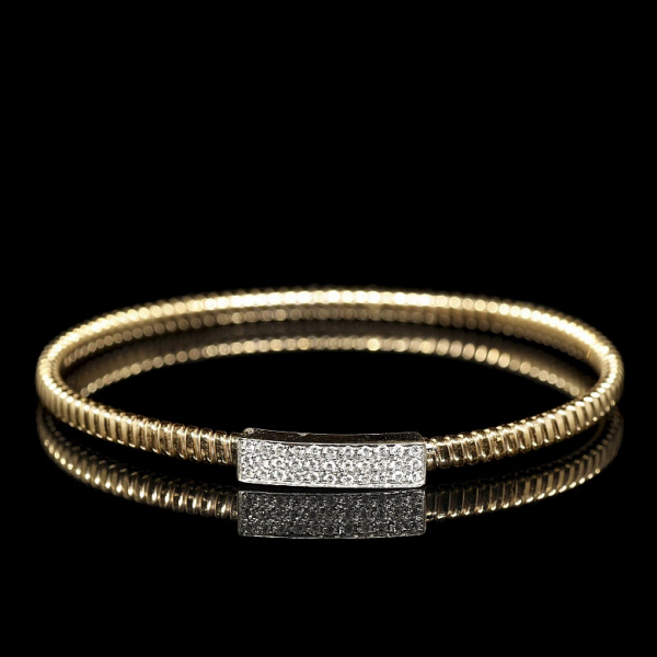 Pulsera rígida de oro amarillo de 18 kt, con diseño tubular flexible y placa con diamantes.