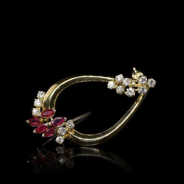 Broche de oro amarillo de 18 kt con cinco rubíes talla marquesa y diamantes. 