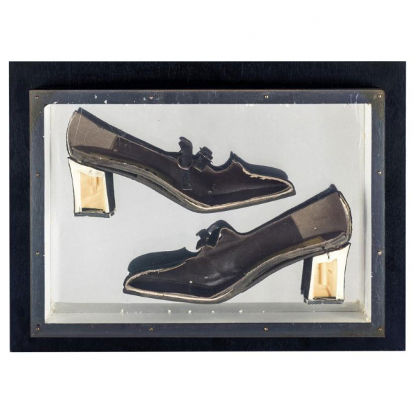 Arman. "Construction of shoes (1965)". Zapato de tacón (coupe) sobre panel de madera negra con cubierta de plexiglás.