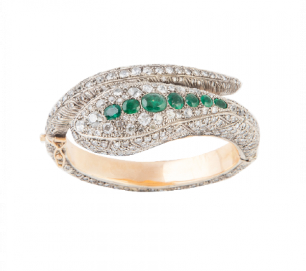 Brazalete con diseño de serpiente cuajada de brillantes de talla antigua que suman 18K aprox y esmeraldas que suman 4,5 ct aprox.  En oro amarillo de 18K con vistas de plata.
