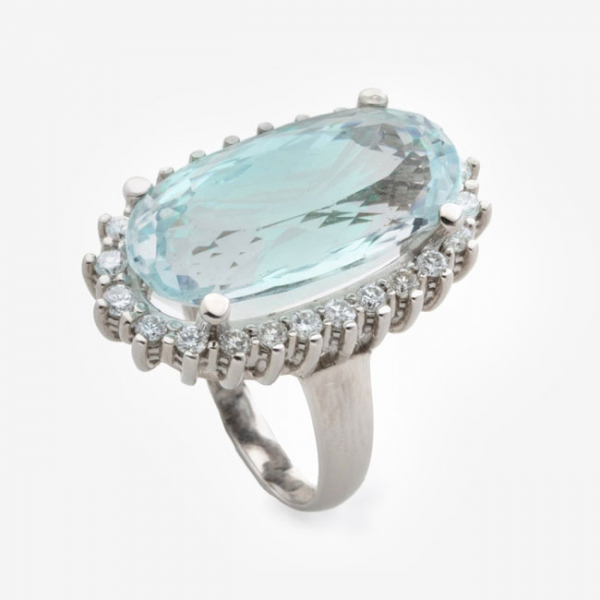 Sortija en oro blanco con aguamarina oval central y orla de diamantes talla brillante alrededor con un peso total de 1,5 cts.