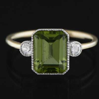 Anillo en oro blanco y oro amarillo de 18 kt con peridoto central de dos brillantes.