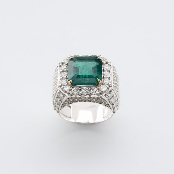 Sortija diseño sello en oro blanco con esmeralda central talla octogonal y cuerpo cuajado de diamantes talla brillante.