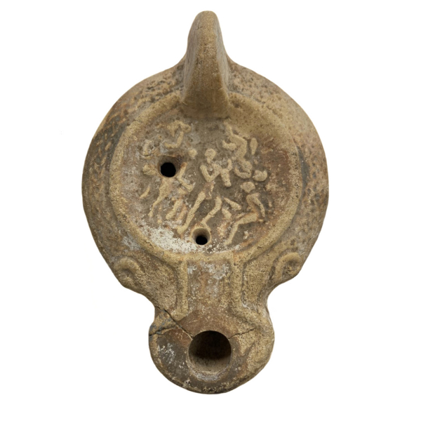 Lámpara romana del siglo II. En cerámica naranja clara con restos de barniz.