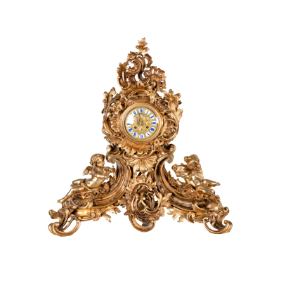 Reloj de sobremesa estilo Luis XV en bronce dorado con decoraci&oacute;n floral, de rocallas, roleos y acantos, custodiado por pareja de puttis, s.XIX.
