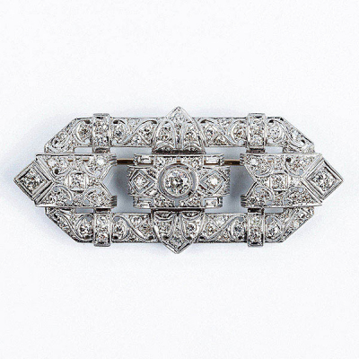 Alfiler-plaqueta estilo &#039;art-decó&#039;, años 40-50, en montura calada de oro blanco, con diamante central, talla brillante