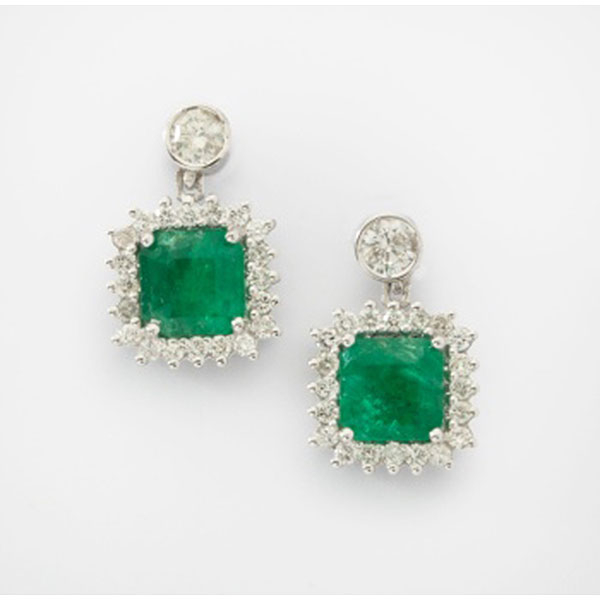 Pendientes en oro blanco de colgar con esmeralda central y orla de diamantes talla brillante  con un peso total de 0,68 cts. aprox.