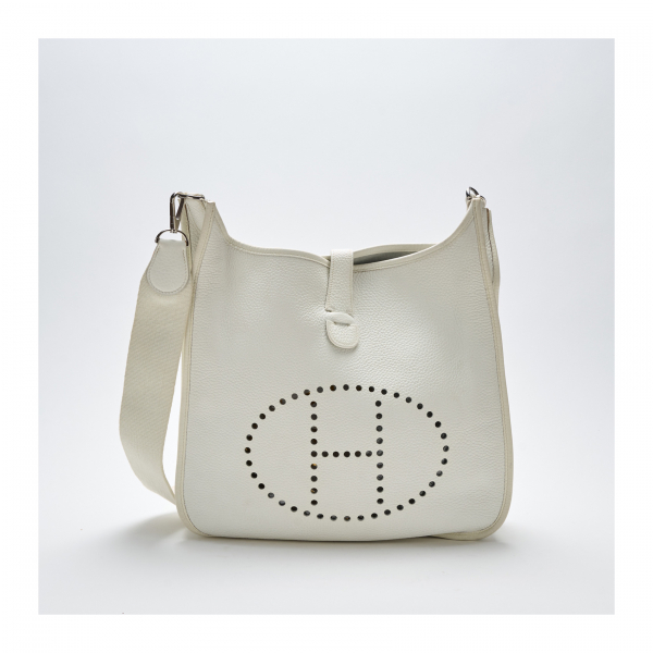 HERMÈS. Bolso modelo «Evelyn» en piel blanca calada con cierre de click. En muy buen estado.