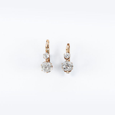Bonitos pendientes zarcillo antiguos en montura de oro amarillo 18 K con dos limpios y blancos diamantes naturales, talla 'cushion' antigua, en garras