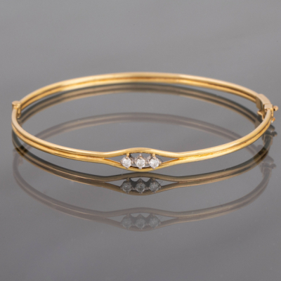 Pulsera de media caña en oro amarillo de 18kt con tres brillantes en el frontal.