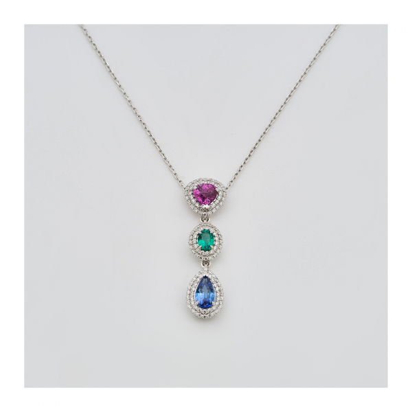 Gargantilla en oro blanco con tres rosetones de rubí talla trillón, esmeralda oval y zafiro azul talla perilla orlados por diamantes talla brillante.