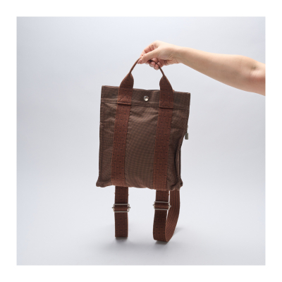 HERMÈS. Mochila modelo «Herline» en lona de tonalidad marrón con asas y correas ajustables