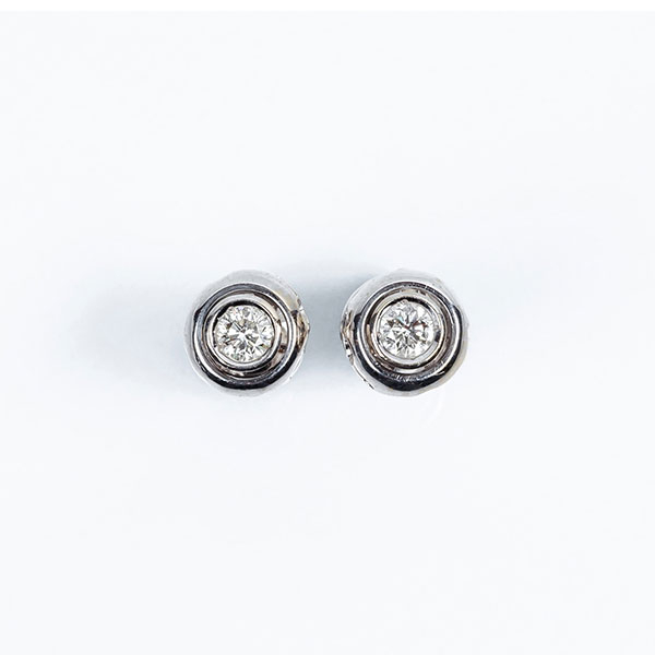 Pendientes solitarios en s&oacute;lida montura de oro blanco con un limpio y blanco diamante talla brillante en chat&oacute;n