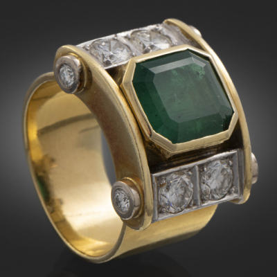 Anillo en oro amarillo de 18 kt con esmeralda central y brillantes.