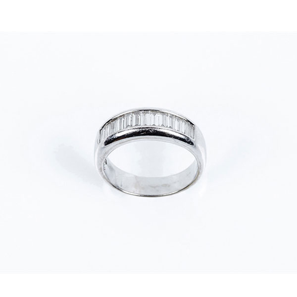 Anillo media alianza en sólida montura de oro blanco con frente en fila de limpios y blancos diamantes talla baguette.