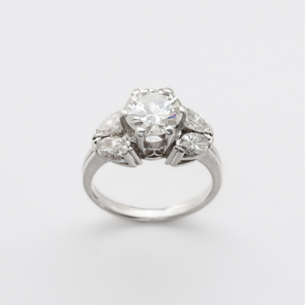 Sortija en oro blanco con diamante central talla brillante custodiado por parejas de diamante talla marquise.