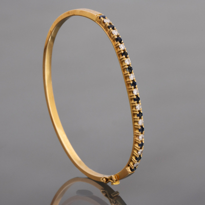 Pulsera rígida en oro amarillo de 18kt con zafiros y brillantes.
