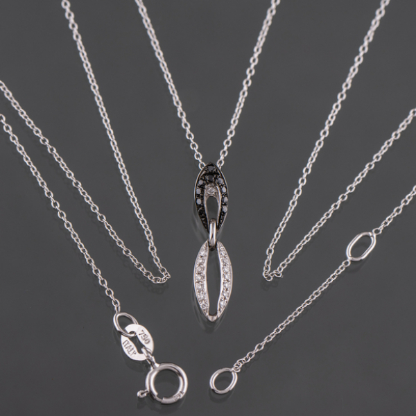 Cadena en oro blanco de 18 kt con colgante cuajado de brillantes blancos y negros.