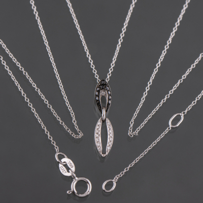 Cadena en oro blanco de 18 kt con colgante cuajado de brillantes blancos y negros.
